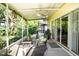 Relaxing screened porch with seating area, ceiling fan, and lush garden views at 708 Canberra Rd, Winter Haven, FL 33884