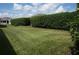 Landscaped backyard with green lawn and hedges at 3832 Traditions N Blvd, Winter Haven, FL 33884