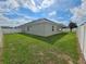 Large grassy backyard with a white vinyl fence at 991 First Dr, Eagle Lake, FL 33839