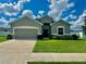 One-story house with gray siding and two-car garage at 991 First Dr, Eagle Lake, FL 33839