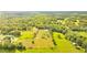 Aerial view of a large property with lush green pastures, trees, and a home at 5303 Tillman Rd, Lakeland, FL 33810