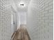 Bright hallway with white brick walls and light wood flooring at 5303 Tillman Rd, Lakeland, FL 33810