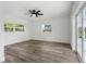 Bright bedroom with wood-look floors, ceiling fan, and French doors leading to patio at 5303 Tillman Rd, Lakeland, FL 33810