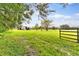 Serene pasture with lush grass, mature trees, and a rustic gate at 5303 Tillman Rd, Lakeland, FL 33810