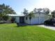 Single-story house with a two-car garage and a lawn at 2201 W Pilaklakaha Ave, Auburndale, FL 33823