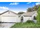 White two-car garage with gated access to the backyard at 34415 Kingfish St, Fruitland Park, FL 34731