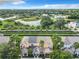 Aerial view showcasing a row of townhouses with palm trees and a pond at 1532 Still Dr, Clermont, FL 34714