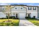 Two-story townhome with a gray exterior, two-car garage, and landscaping at 955 Grandin St, Davenport, FL 33837