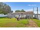 Back view of tan house with deck and fenced yard at 5711 Cherry Tree Dr, Lakeland, FL 33811