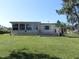 Single-story home with a large grassy yard and a deck at 2201 W Pilaklakaha Ave, Auburndale, FL 33823