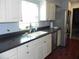 Kitchen with double sink, white cabinets, and dark countertop at 2201 W Pilaklakaha Ave, Auburndale, FL 33823