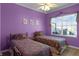 Bedroom with two twin beds, lavender walls and floral bedding at 3820 Traditions N Blvd, Winter Haven, FL 33884