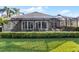 Back of house with lush landscaping and screened patio at 3820 Traditions N Blvd, Winter Haven, FL 33884
