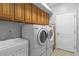 Bright laundry room, washer, dryer, cabinets, and utility sink at 3820 Traditions N Blvd, Winter Haven, FL 33884