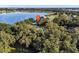 Aerial view of a lakefront property with a home nestled among the trees at 126 Bermuda Ct, Winter Haven, FL 33880