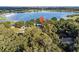 Aerial view showing home's location on a lakefront lot with lush landscaping at 126 Bermuda Ct, Winter Haven, FL 33880