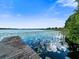 Picturesque lakefront view with a wooden dock and lily pads at 126 Bermuda Ct, Winter Haven, FL 33880