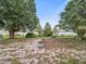 Lakefront property with a sandy area, lush trees, and tranquil waters at 126 Bermuda Ct, Winter Haven, FL 33880