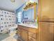 Clean bathroom with light wood vanity, shower, and bird-themed curtain at 126 Bermuda Ct, Winter Haven, FL 33880