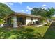 Back of house with sliding glass doors opening to a patio and grassy yard at 466 Muirfield Ct, Winter Haven, FL 33884