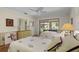 Guest bedroom with twin beds, dresser, and view of backyard patio at 466 Muirfield Ct, Winter Haven, FL 33884