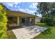 Landscaped backyard with large patio and partial view of neighboring home at 466 Muirfield Ct, Winter Haven, FL 33884
