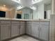 Double vanity bathroom with granite countertops and gray cabinets at 13515 Lake Yale View Loop, Grand Island, FL 32735