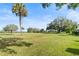 Landscaped backyard with lush grass and palm trees at 6001 Country Club Dr, Lake Wales, FL 33898