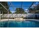 Relaxing swimming pool with screened enclosure and stone waterfall at 672 Wakulla Dr, Winter Haven, FL 33884