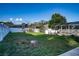 Spacious backyard with a large grassy area, a white fence, and a pool enclosure at 672 Wakulla Dr, Winter Haven, FL 33884
