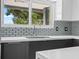 Modern kitchen sink and countertop with gray cabinets and light-blue backsplash at 430 N Omaha St, Lake Hamilton, FL 33851