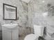 Clean bathroom with marble-style tile, a toilet and a vanity at 430 N Omaha St, Lake Hamilton, FL 33851