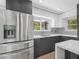 Stainless steel refrigerator in modern kitchen with gray cabinets at 430 N Omaha St, Lake Hamilton, FL 33851
