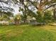Large backyard with playset, trampoline, and mature trees at 3511 Avenue R Nw, Winter Haven, FL 33881