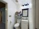 Small bathroom with toilet, sink, and shelving at 3511 Avenue R Nw, Winter Haven, FL 33881