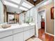 Bathroom with white vanity, striped wallpaper and a large mirror at 209 Santa Rosa Dr, Winter Haven, FL 33884