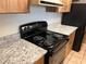 Black electric range and granite countertops in this kitchen at 1039 Medinah Dr, Winter Haven, FL 33884