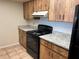 Kitchen with wood cabinets, granite counters, and black appliances at 1039 Medinah Dr, Winter Haven, FL 33884