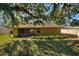 House backyard view, featuring a large, grassy yard and mature trees providing shade at 222 Okaloosa Dr, Winter Haven, FL 33884