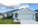 Newly built home with gray siding, two-car garage, and well-manicured lawn at 1274 Zambrana Ct, Winter Haven, FL 33884