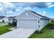Newly constructed light green house with a two-car garage and landscaped yard at 1274 Zambrana Ct, Winter Haven, FL 33884