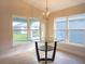 Bright breakfast nook with glass-top table and chandelier, offering views to backyard at 1274 Zambrana Ct, Winter Haven, FL 33884