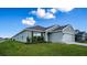 Newly built home with gray siding, two-car garage, and a spacious lawn at 1274 Zambrana Ct, Winter Haven, FL 33884