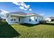 Exterior view of a light blue house with a covered patio and well-maintained lawn at 1274 Zambrana Ct, Winter Haven, FL 33884