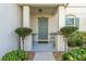 Charming front porch with grey door and potted plants at 940 Waterville Dr, Auburndale, FL 33823