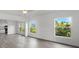 Living room with hardwood floors, multiple windows, and open concept to kitchen at 1800 4Th Nw St, Winter Haven, FL 33881