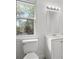 Clean bathroom with white vanity, toilet and shower. Features a large window and mirror at 1800 4Th Nw St, Winter Haven, FL 33881