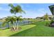 Backyard with a lake view, palm trees, and a grassy lawn at 193 Stargrass Dr, Auburndale, FL 33823
