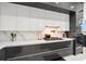 Modern kitchen features sleek dark and white cabinets, marble countertops, and stainless steel appliances at 193 Stargrass Dr, Auburndale, FL 33823