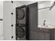 Modern laundry room with stacked washer and dryer, and a convenient sink at 193 Stargrass Dr, Auburndale, FL 33823
